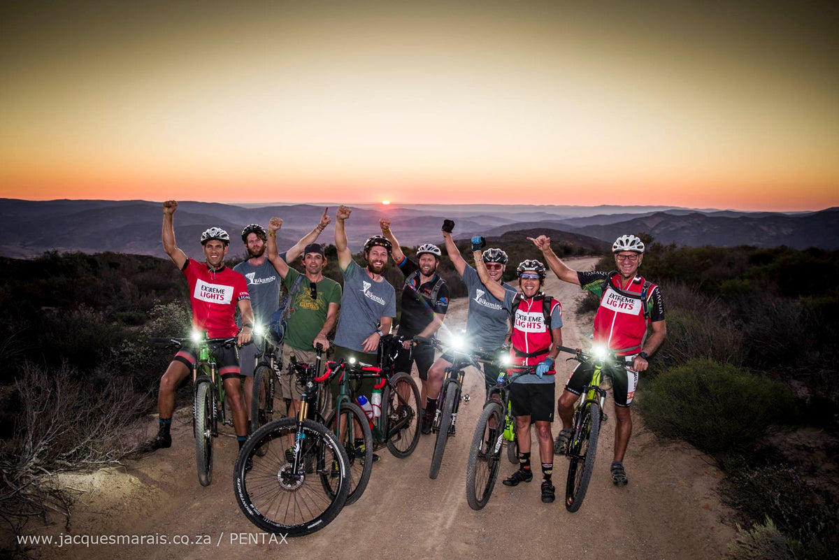 Extreme Lights riders celebrating at sunset in the mountains